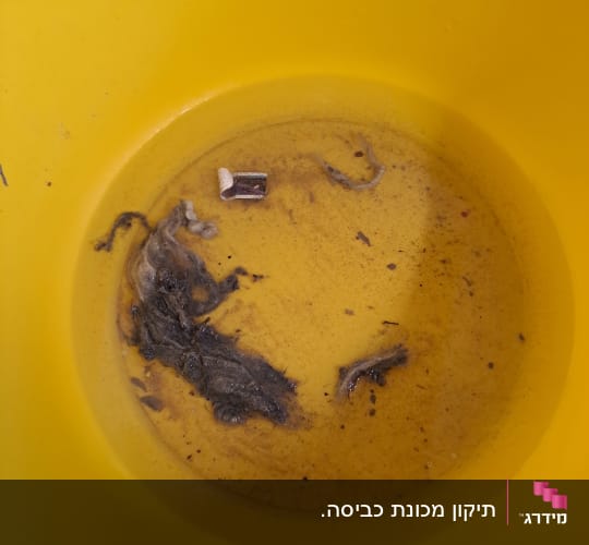 דלי צהוב ובו פסולת ולכלוך שחולצו מסיפון או פילטר במהלך שירות תיקון
